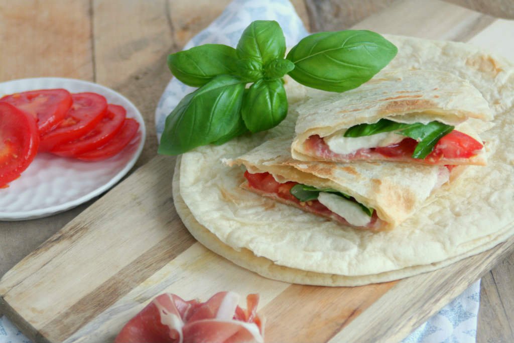 Piadina (Italiaans platbrood) met mozzarella, tomaat en rauwe ham