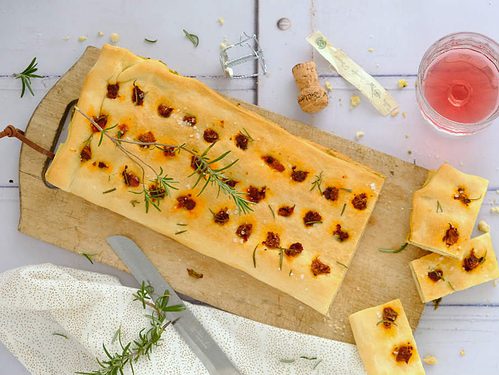 Een snelle focaccia met pesto en zongedroogde tomaat maak je makkelijk met een verse rol pizzadeeg. Dit hapejs recept serveer je warm of koud.