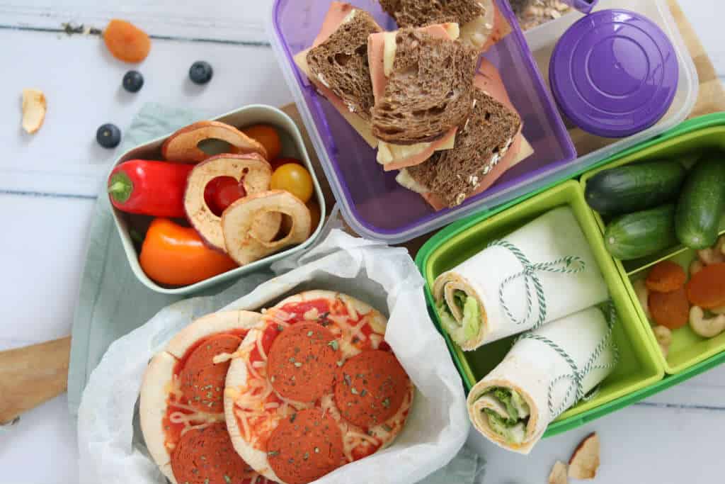 3 x vega lunchbox inspiratie voor kinderen met een vegan kip wrap met hummus, een pita pizza en een sandwich hawai. Makkelijke en snelle lunchrecepten.
